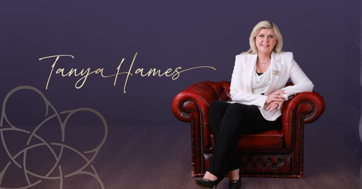 Rapid Transformational Therapy interview with Dr Tanya Hames. Tanya sits in a read leather chair dressed in a white top and blazer.